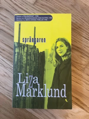 Sprängaren av Liza Marklund - Spännande kriminalroman av Liza Marklund med gul och svart omslag. Boken handlar om journalisten Annika Bengtzon och ett dramatiskt mordfall kopplat till OS i Stockholm. Pocketutgåva från Ordfront, perfekt för dig som gillar deckare och thrillers.