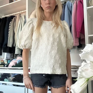 Ljusgul blus med puffärm från VILA - Superfin blus från VILA som endast blivit använd 2 gånger tyvärr, färgen är en nyans av ljusgul nästan vit och ger en väldigt classy look. Ryggen är dekorerad med tre knytningar