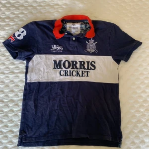 Blå pikétröja från Morris - Säljer en blå pikétröja från Morris med röd krage. Snygg piké perfekt nu inför sommaren, storleken är L men passar även M då det är en liten L storlek. Pris går att diskuteras skriv för mer frågor :)