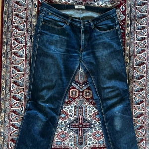 Mörkblå jeansbyxor från Acne - Coola mörkblå acne jeans med en rak passform och är i slitstarkt denim, den är i en dragkedja gylf. Jag har gjort en osynlig lagning på insidan av jeansen som inte syns vid skreven