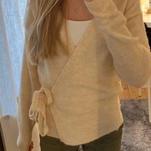 Beige omlottkofta - Säljer denna super mysiga omlott koftan. Koftan är väldigt stretchig och har långa band så passa många olika storlekar!💕