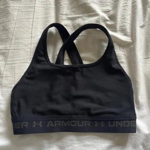 Sport BH - En oanvänd sport BH från Under Armour i storlek S. Korsade band baktill och medföljande inlägg. Säljer då den är för liten. Pris är diskuterbart   Hör av dig vid frågor 