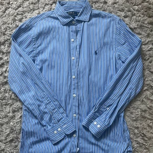 Ralph Lauren skjorta - Randig skjorta från Polo Ralph Lauren i storlek 15 1/2 vilket motsvarar cirka M. Modellen är slim fit. Skitsnygg till sommaren! Hör av er vid eventuella frågor.