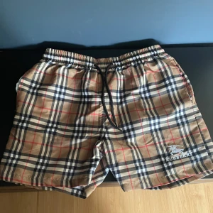 Burberry badshorts - Säljer dessa riktigt stiliga badbyxorna/shortsen från Burberry i storlek M. Byxorna är perfekta nu inför sommaren för o visa elegans på stranden😉Något tajta i storleken så passar dig med S också perfekt! Plagget är enbart testade o i nyskick. Burberry lapp ifrån byxorna finns ifall de skulle vara intressant. Hör gärna av dig vid funderingar och innan köp!