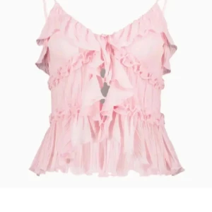 Ljusrosa volang topp med tunna axelband - Säljer en söt ljusrosa topp med volangdetaljer och tunna axelband. Toppen är croppad och har en romantisk känsla med plisserad nederdel och volanger framtill. Perfekt för sommardagar eller när du vill känna dig extra fin. Helt ny!