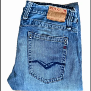 Blå Replay jeansbyxor med raka ben - Säljer ett par klassiska blå jeans från Replay med raka ben och snygga detaljer på bakfickorna. Jeansen har normal passform och är tillverkade i slitstarkt denim. Perfekta för dig som gillar en tidlös stil. Tveka inte på att höra av dig vid frågor!