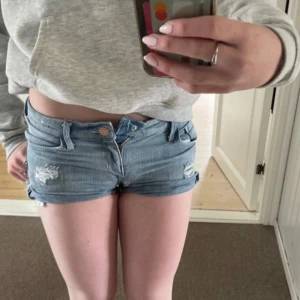 Snygga jeansshorts med slitningar - Jättefina lågmidjade ljusblå jeansshorts med slitna detaljer framtill. Perfekta nu inför sommaren, i väldigt fint skick säljer då de blivit för små💗Skriv ifall ni har några funderingar😁