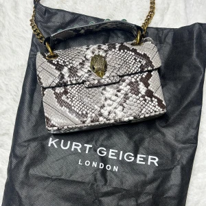 kurt geiger mini kensington ormskinn - Ovanligare Kurt Geiger väska i ormskinn (ej äkta ormskinn) Nyskick. Dustbag medföljer. Köpt för 2500kr. Det lilla handtaget är avtagbart. Köp sker via köp nu, jag postar inom 24h. Kvar tills markerad såld