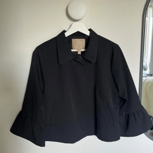 Svart kavajjacka med volangärm - Säljer denna supersnygga koftan/jackan från Culture. Nypris ca 1200kr. Kan användas både som jacka och tröja. Storlek 34 men passar även mig som brukar ha 36. Aldrig använd. Hör av dig vid frågor🖤