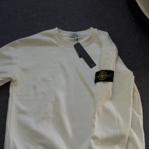 Vit långärmad tröja  från Stone Island - Säljer en clean vit långärmad tröja  från Stone Island med klassisk logga på ärmen. . 