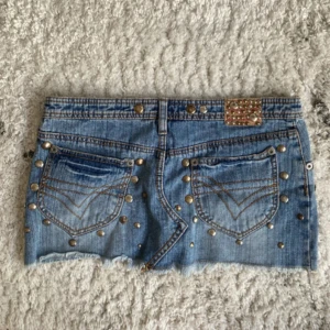 Lowwaist mini jeanskjol med skimrande nitar - Snygg low waist mini jeanskjol i strl 36, kommer massor av liknande unika plagg så följ!!