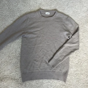 Beige merinoulltröja från John Henric - Snygg beige tröja i 100% merinoull från John Henric. Klassisk rund halsringning, ribbade muddar och lång ärm. Perfekt för dig som gillar stilrena och mjuka plagg med en clean look. Storlek S men sitter som Xs pga krymt lite i tvätten, köpt för 1299 säljer för 499 endast!
