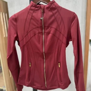 Vinröd träningsjacka från Lululemon - Snygg vinröd träningsjacka från Lululemon med guldiga dragkedjor. Skit snygg!! Storlek 6 vilket motsvarar storlek S. Är öppen för att bya mot en annan färg i 4 eller 6 också!!❤️