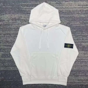 Vit hoodie från Stone Island - Säljer en clean vit hoodie från Stone Island med klassisk patch på vänster ärm. Hoodien har huva med snörning, stor magficka och ribbade muddar. Perfekt för dig som gillar streetwear och vill ha en enkel men snygg look.