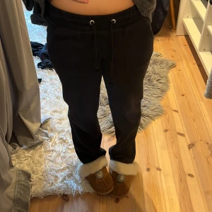 Svarta mjukisbyxor med snörning - Svarta mjukisbyxor med dragsko i midjan och bootcut ben. Byxorna har en avslappnad passform och är perfekta för chill dagar hemma. Tillverkade i mjukt material💞