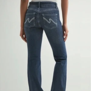 Blå bootcut jeans med broderade fickor - Snygga blå jeans med bootcut passform och coola broderade detaljer på bakfickorna. Klassisk femficksmodell med normal midja och skön stretch. Perfekta till sneakers eller boots.