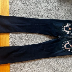 Mörkböå true religion jeans - Superfina mörkblå true religion jeans med rosa detaljer på fickorna. Använda ett fåtal gånger, mycket bra skick. Köpt för ca 2200kr på raglady 