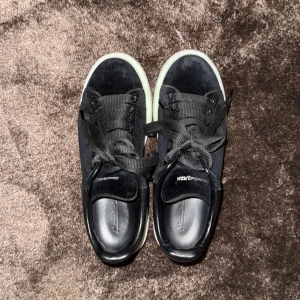 Svarta sammets sneakrs från Alexander McQueen - Stilrena svarta sammets sneakers från Alexander McQueen med bred vit plattformssula. Skorna är använd endast några fåtal gånger och smuts på vita delen av sulorna går att få bort på egen hand. Köpt för 5000 kr men säljer för 1000kr. 