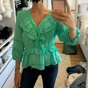 Långärmad neo noir blus - Super snygg och cool grön blus med volanger från Neo Noir!! Den är i ett lätt linnetyg som gör att den känns väldigt luftig. Sparsamt använd och säljer endast då den inte kommit till användning på ett tag