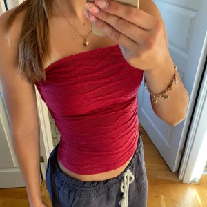 Röd tubtopp - Säljer en mörkröd bandeau tubtopp i storlek S. Säljer då jag köpte den men aldrig använt den. Skriv gärna vid funderingar eller fler bilder.💕