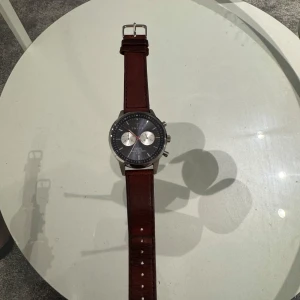 Triwa Nevil klocka med brunt läderband - Stilren Triwa Nevil klocka, funkar till allt , ny pris 2599 , har används en del som man kan se lite på armbandet men har mycket kvar att erbjuda, vid fler frågor och funderingar är de bara att höra va sig, mvh