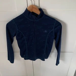 Marinblå half zip tröja Mountain Horse - Säljer en marinblå långärmad tröja från Mountain Horse med half zip och hästmönster över hela. Liten i storleken men det står 160.