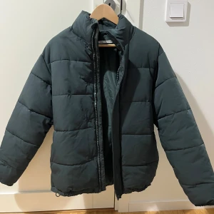 Mörkgrön pufferjacka från Zara - Säljer en mörkgrön pufferjacka från Zara i storlek S. Jackan har hög krage, dragkedja och tryckknappar framtill samt quiltad design. Perfekt för kalla dagar och har en clean, stilren look som funkar till det mesta.Öppen för bundles och frågor!  Man, kille, grisch, Stockholm, plagg, billigt, small, s, stil, stiligt, style, jacka, tröja, skjorta, kvalitet, märke, märkeskläder