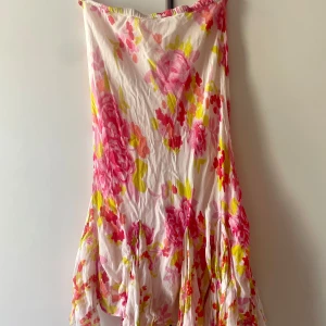 Blommig kjol från Sun Wear - Säljer en långkjol  från Sun Wear med blommigt mönster i rosa, gul och vit. Den är köpt second hand men är i bra skick. Skulle säga att den passa strl s-m 🫶💕
