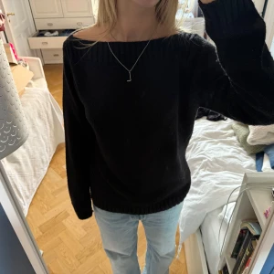 Svart stickad tröja - Svart stickad tröja med boat neck som också kan bäras offshoulder. Långärmad och mjuk, med ribbade muddar vid ärmslut och nederkant. Lite konstig storlek på den men den sitter snyggt oversized på mig som har S/M 36/38