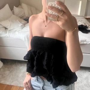 Svart axelbandslös topp - Svart volang topp/kjol, kan användas som båda. Storlek är petite S från Shein. Som topp passar de nog som xxs eller xs