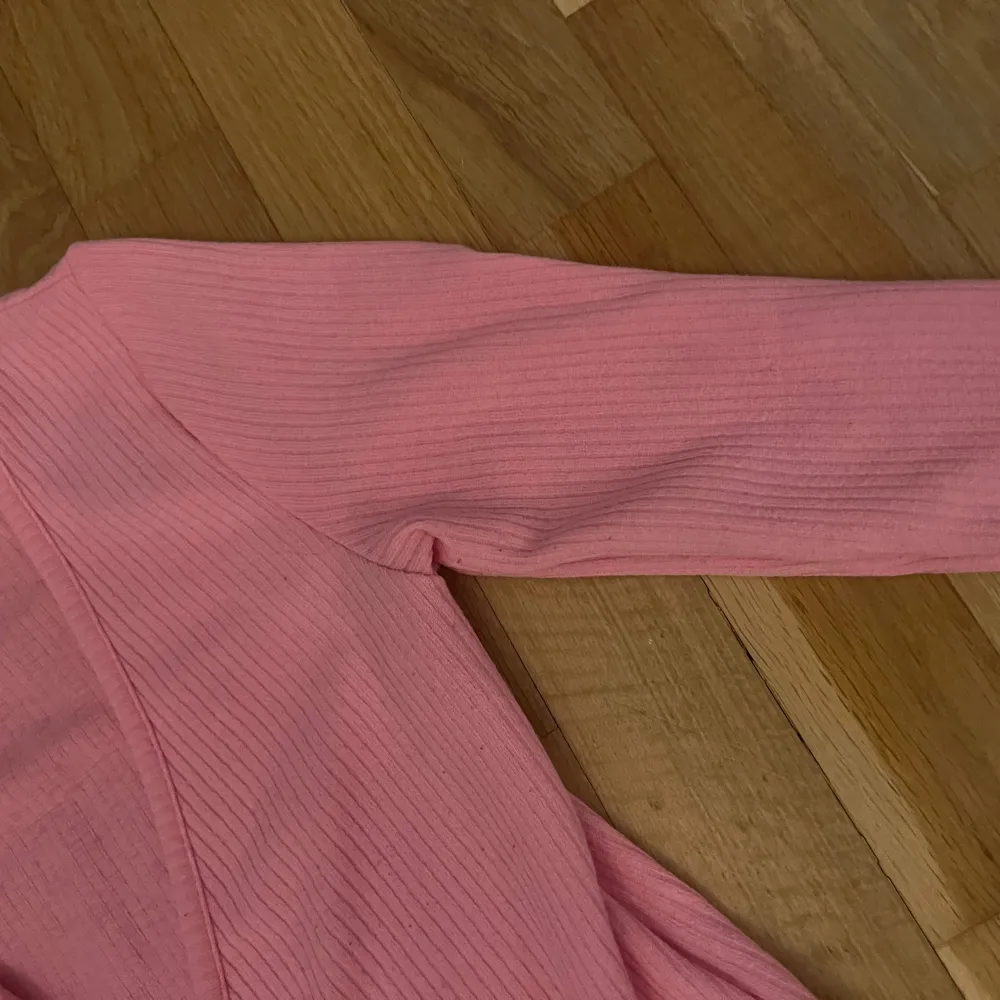 Säljer en söt rosa ribbad kofta från H&M. Den har långa ärmar och en knytning framtill. Perfekt för att lägga till en färgklick i garderoben. Passar bra till både jeans och kjol.. Neuletakit & Villapaidat.