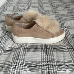 Beige sneakers med pälsdetalj från Steve Madden - Snygga beige sneakers från Steve Madden med en päls detalj på ovansidan. Skorna har en tjock vit sula, och är i storlek 38. 