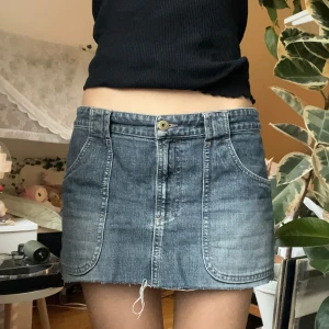 Jeanskjol från H&M 💗 - Säljer en snygg jeanskjol från H&M i klassisk blå denim. Kjolen har en kort längd med fickor både fram och bak samt en dekorativ bältesdetalj bak, enda saken som kan noteras är att den har lite lösa trådar och är lite ojämn då den är klippt av tidigare ägare, men inget som märks speciellt! 💗