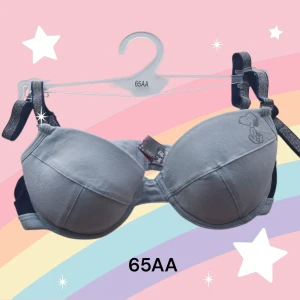 Ljusblå BH med Snoopy-motiv 65AA - Söt ljusblå BH med ett charmigt Snoopy-motiv. Tillverkad av 95% bomull och 5% elastan för en bekväm passform. Perfekt för dig som älskar en lekfull och avslappnad stil. Justerbara axelband med glittrig detalj för extra stil. Banden är avtagbara. Uttagbara inlägg. Ny med lapparna kvar. Finns fler liknande annonser med möjlighet till rabatt om du köper flera.