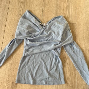 Ljusblå omlottopp från Zara - Snygg ljusblå omlottopp från Zara med långa ärmar. Perfekt för en stilren look. Tillverkad i ett mjukt material som ger en bekväm passform.🩷