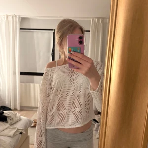 Vit stickad tröja - Säljer en vit stickad tröja med ett luftigt och mönstrat design. Tröjan är croppad och har långa ärmar. Nästan oanvänd. Storleken är M men passar mig med xs.