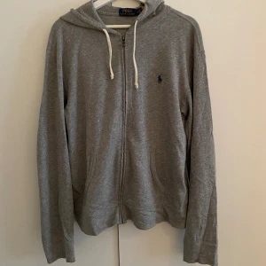 Ralph Lauren zip up - Säljer en grå Ralph Lauren zip up. Skick 9/10. Säljer den för den kommer inte till användning. QR kod funkar. Skriv om du undrar något.