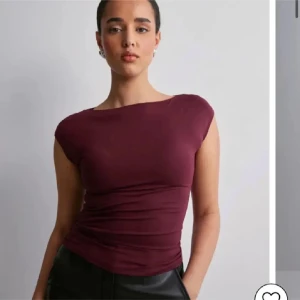 Vinröd topp med korta ärmar - Snygg vinröd topp med korta ärmar och en tight passform. Perfekt för både vardag och festliga tillfällen. Toppen har en enkel och stilren design som gör den lätt att matcha med olika outfits.