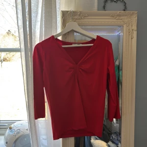 Röd långärmad topp från A feeling of Joy - Säljer en snygg röd topp från A feeling of Joy. Den har en v-ringad design med en liten rynkdetalj framtill. Perfekt för att lägga till en färgklick i garderoben❣️ Storlek M!!!❣️