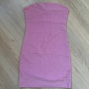 Rosa glittrig klänning - Rosa glittrig klänning med dubbelt tyg längst upp. Använd 1 gång. 