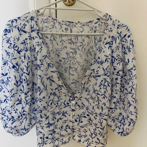 Blommig blus  - Blus med blommor från hm. Förliten för mig därav inga bilder med den på. En knapp är sönder men går att laga. Storlek xs/s 50kr