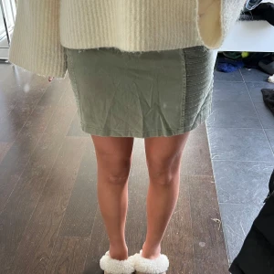 Grön kjol  - Snygg grön kortkjol med dragkedjor framtill. Kjolen har en tight passform och är tillverkad i ett bekvämt material. Perfekt för att ge en cool touch till din outfit. Kjolen är mer mot de högmidjade hållet🩵. 