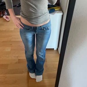 Lågmidjade Blå bootcut jeans - Snygga blå bootcut jeans med låg midja och klassisk femficksdesign. Jeansen har en lätt tvättad look och knappar på bakfickorna samt sömdetaljer för extra stil. Perfekta för en avslappnad look. Jag är 165 för referens ❤️‍🔥