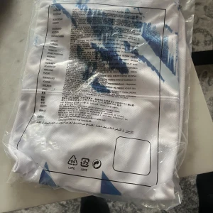 Vit fotbollströja från Nike - Säljer en vit fotbollströja från Nike med blå detaljer och nummer 10 på ryggen. Perfekt för fotbollsfans som vill visa sitt stöd. Tröjan är kortärmad och har en sportig design.