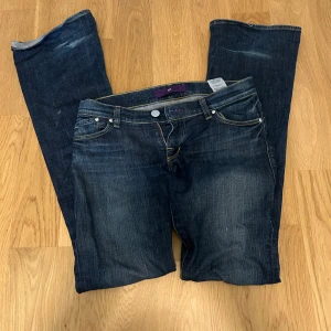 bootcut Victoria Beckham jeans - Snygga mörkblå bootcut jeans från victoria Beckham i storlek 28/32 med klassisk femficksdesign och kontrasterande sömmar. Jeansen har en dragkedja och knapp framtill samt en broderad logga på bakfickan. Perfekta för en avslappnad stil. Köpta i USA för ca 690$
