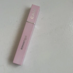 Rosa mascara från CAIA - Snygg rosa mascara från CAIA med en elegant fyrkantig design. Den har en svart borste som ger volym och definition till fransarna. Perfekt för att framhäva ögonen med en dramatisk look.