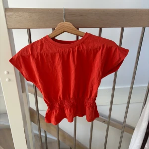 Aprikos croptop - Jättesnygg croppad top från H&M. Den ser väldigt orange ut på bilden men är mer aprikos i vekrligheten. Är i barnstorlekar men passar en XS