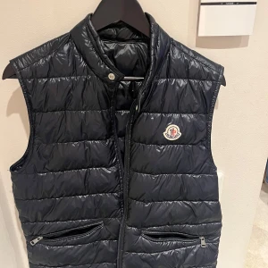 Moncler väst - Snygg blå dunväst från Moncler, jättefint skick och perfekt nu till våren. Storlek 2 vilket motsvarar s/m, priset kan diskuteras vid snabb affär 