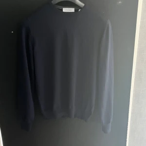 Marinblå tröja från Gran Sasso - Säljer en stilren marinblå tröja från Gran Sasso. Tröjan har en klassisk design med rund hals och långa ärmar. Perfekt för en elegant och tidlös look. Tillverkad i Italien. Tröjan är endast testad alltså sprillans ny. Storlek 48 som motsvarar S/M! Nypris 130€