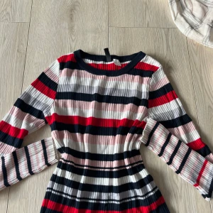 Randig tröja från H&M Divided - Säljer en randig tröja från H&M Divided i rött, svart, vitt och rosa. Klänningen har långa ärmar och en ribbad struktur som ger en snygg passform. Perfekt för en färgglad look!🩷🩷